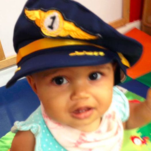 Adorable toddler wearing a biret hat at a Preschool & Daycare/Childcare Center serving Miami, FL.