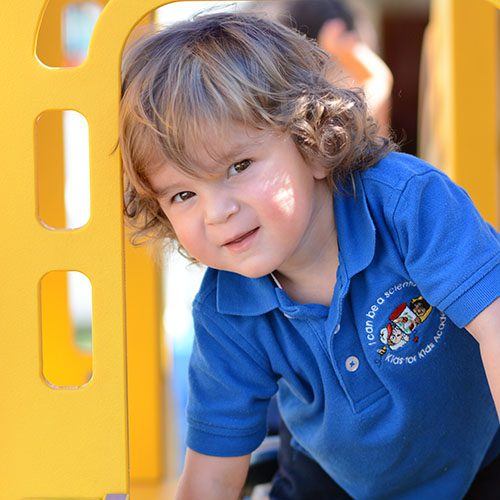 Cute little young kid boy at the playground at a Preschool & Daycare/Childcare Center serving Miami, FL.