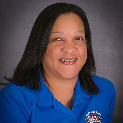 Miriam happy teacher wearing blue school shirt at a Preschool & Daycare/Childcare Center serving Miami, FL.