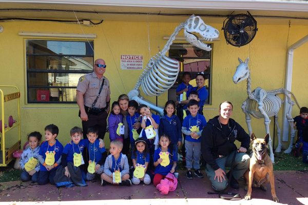 Happy preschoolers with sheriffs and watchdog at a Preschool & Daycare/Childcare Center serving Miami, FL.